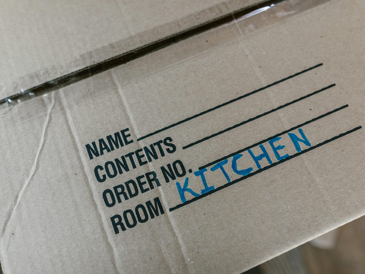 A hand-labeled moving box marked kitchen