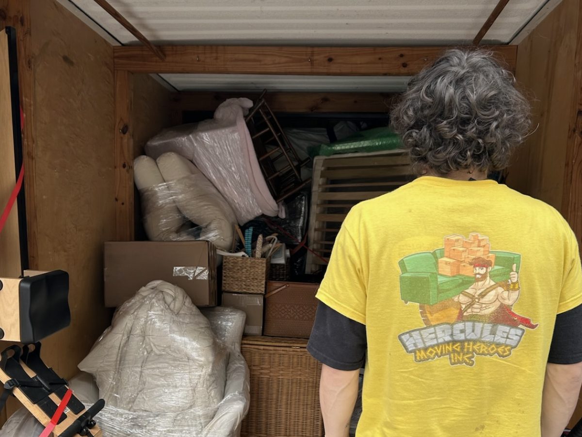 A Hercules crew member, back to the camera, in front of a fully loaded box truck