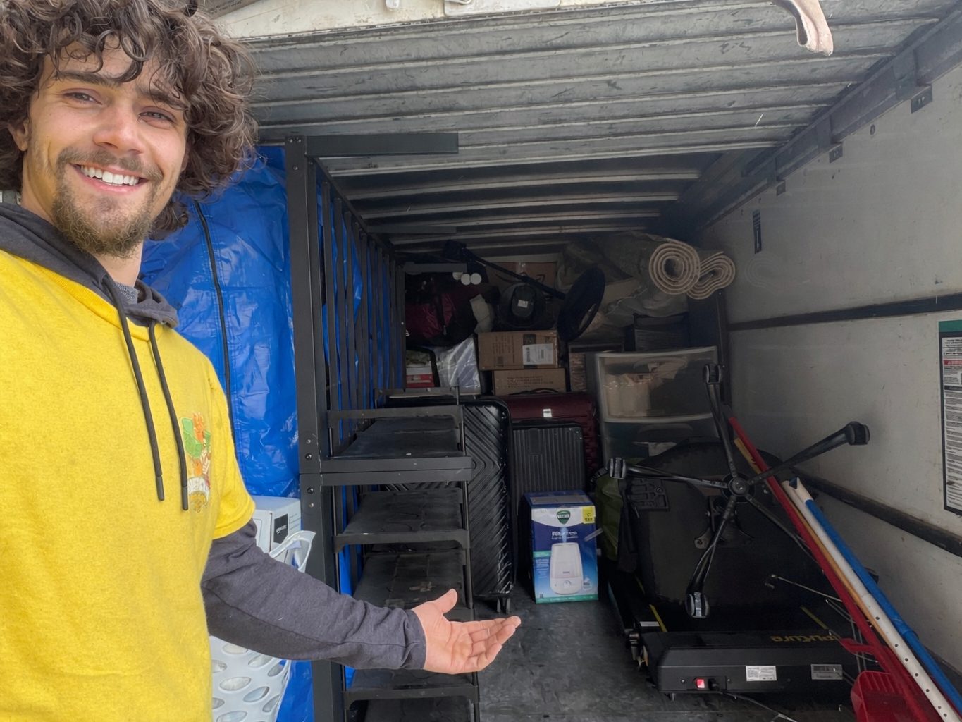 Logan, one of our crew, taking a selfie with a loaded truck behind him