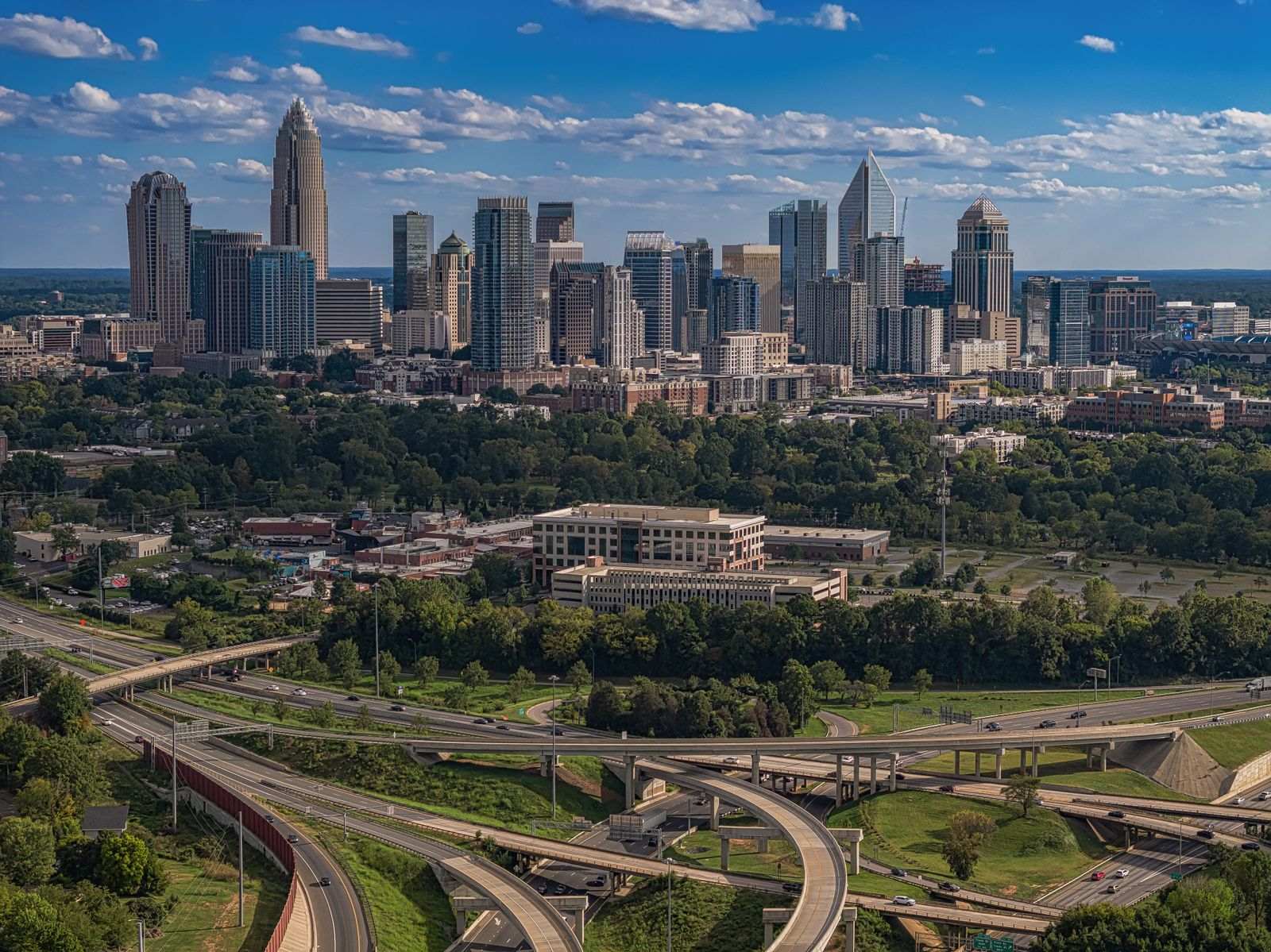 The Charlotte skyline on a clear day with a highway interchange in the foreground