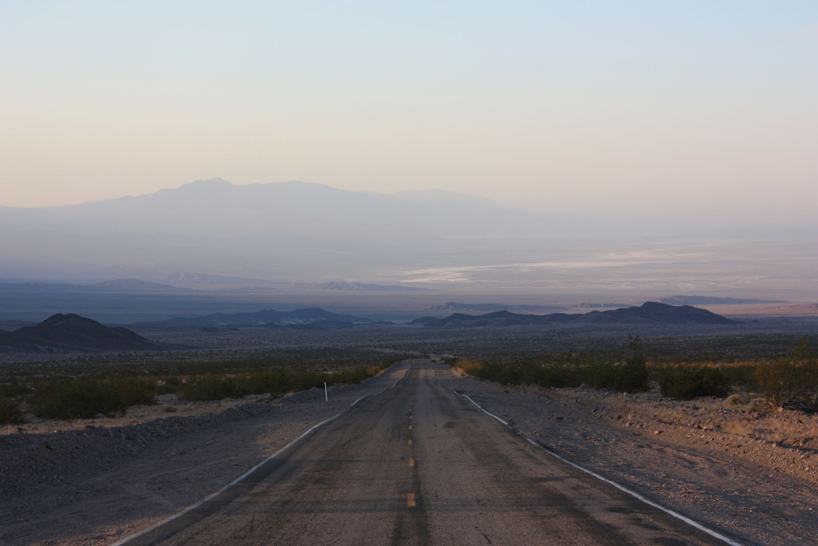 A long empty road running toward distant mountains