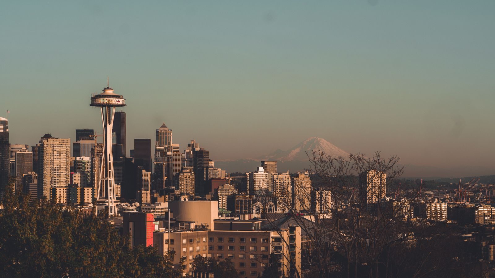The Seattle skyline with the Space Needle and Mount Rainier behind it on a clear evening